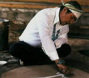 یک داروساز سرخپوست در حال نقاشی بر روی شن. این افراد تلاش می‌کنند بین دنیای انسان‌ها و دنیای ارواح توازن برقرار کنند.